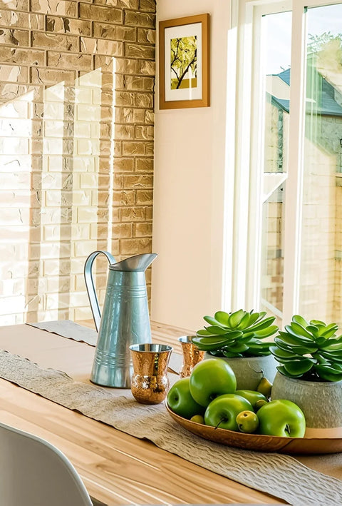 Stylish home dining area with wooden furniture, industrial pendant lighting, and natural sunlight.