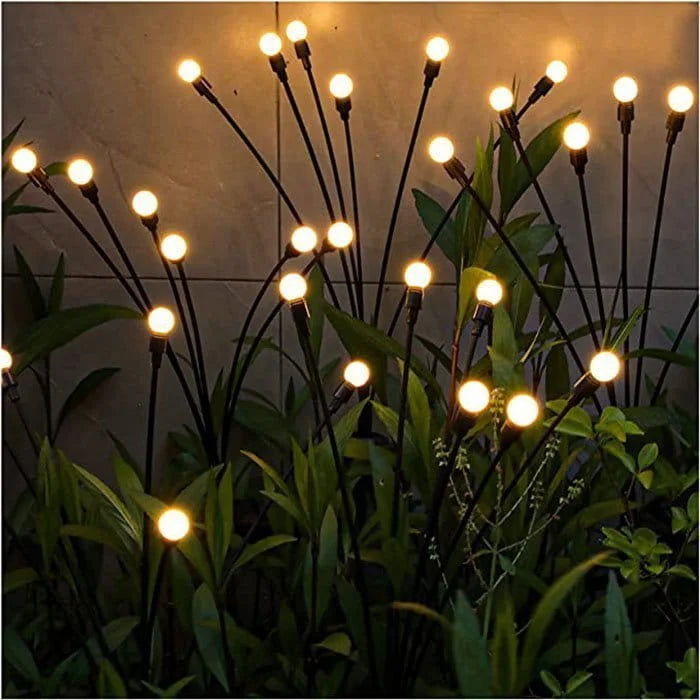 Decorative string lights on plant stems with a dark background