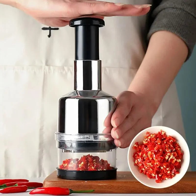 Handheld pepper grinder with red pepper in a clear container, next to a bowl of ground pepper.