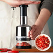 Handheld pepper grinder with red pepper in a clear container, next to a bowl of ground pepper.