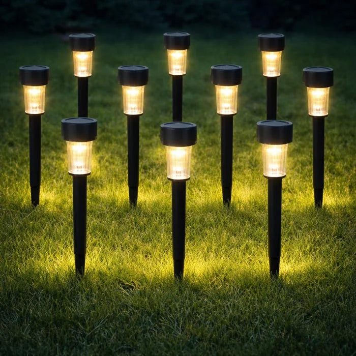 Row of solar garden lights on grass at night