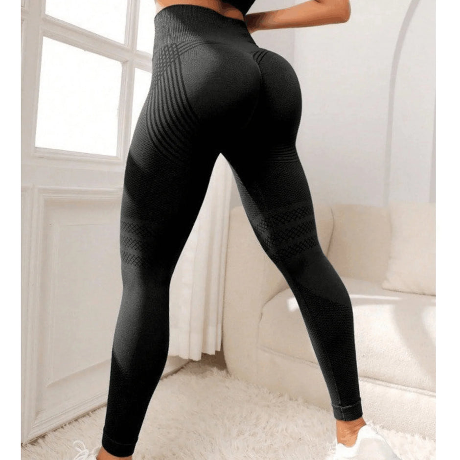 Black leggings worn by a person in a minimalistic room with white walls and furniture.