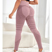Person wearing pink patterned leggings in a bright room with white furniture.
