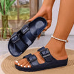 Navy sandals with black buckles worn by a person indoors.
