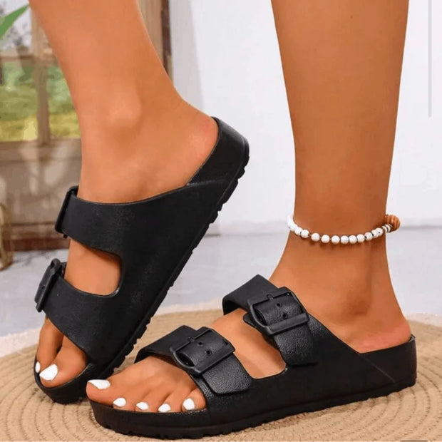 Black sandals worn by a person on a blurred background