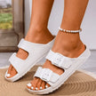 White sandals worn by a person on a blurred background