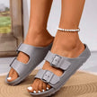 Gray sandals worn on feet with a blurred background