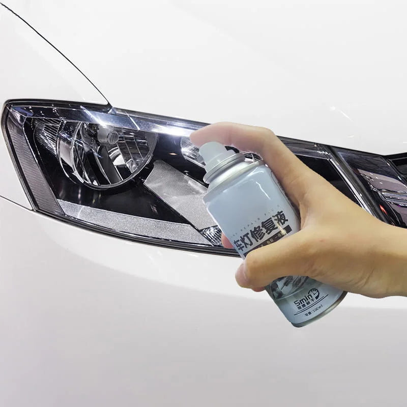 Hand holding a spray can near a car headlight