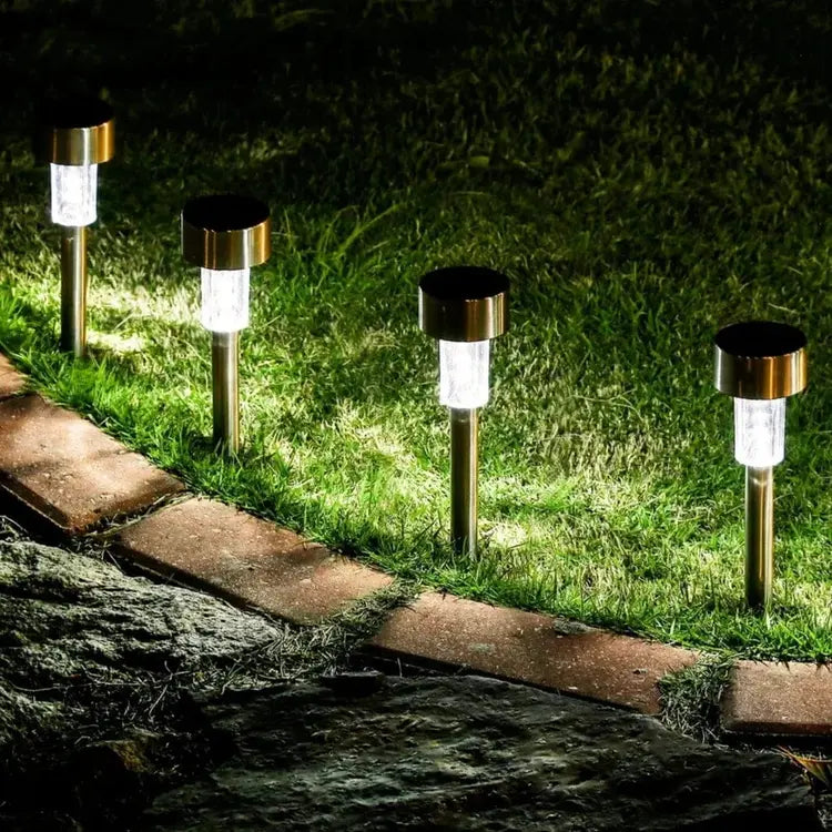 Solar-powered garden lights illuminating a pathway in a grassy area