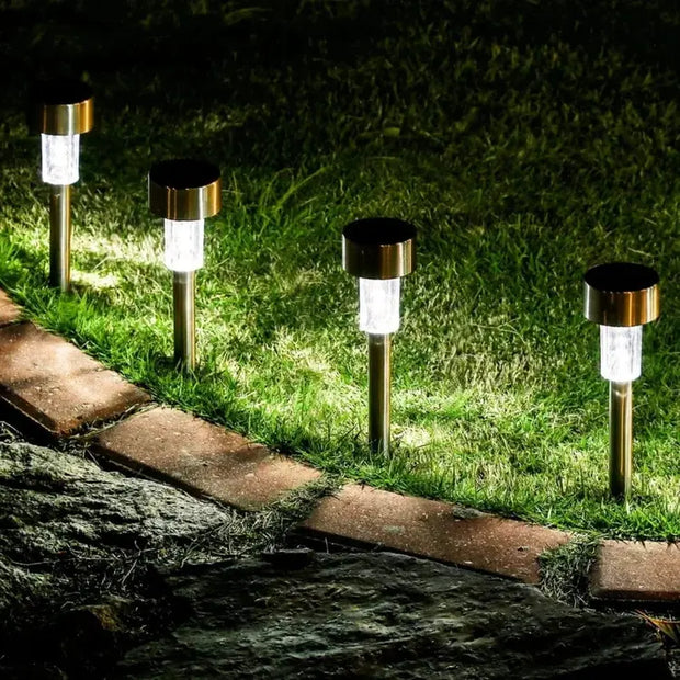 Solar-powered garden lights illuminating a pathway in a grassy area