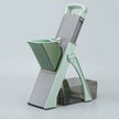 Green and gray kitchen slicer on a light gray background