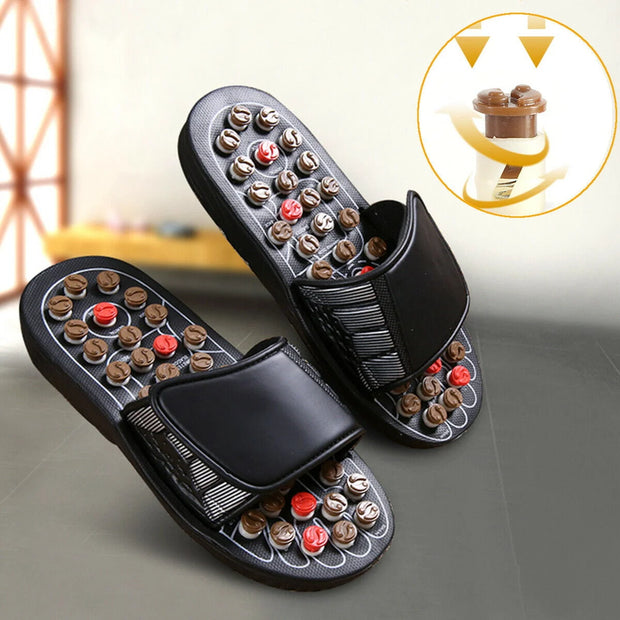 Pair of black massage sandals with embedded nodes on a neutral background