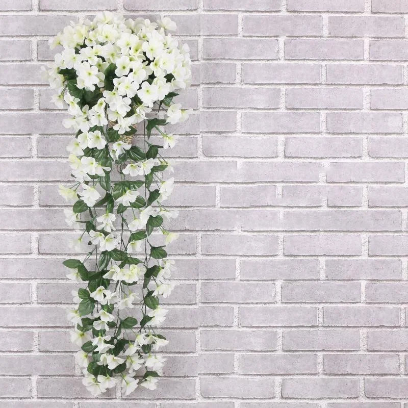 Artificial white flower vine against a gray brick wall