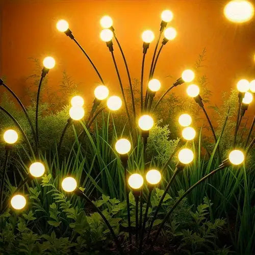 Decorative string lights on plants with a warm glow against a dark background
