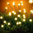 Decorative string lights on plants with a warm glow against a dark background