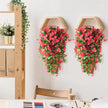 Hexagonal wall planters with pink flowers on a white wall next to a wooden shelf.