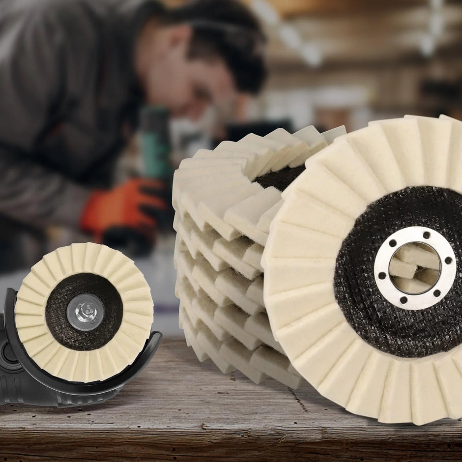 Polishing pads on a wooden surface with a blurred person using a tool in the background