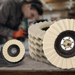 Polishing pads on a wooden surface with a blurred person using a tool in the background