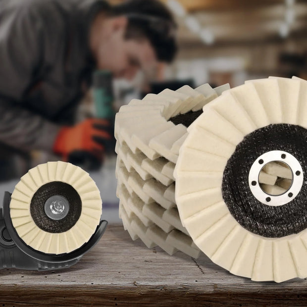 Polishing pads on a wooden surface with a blurred person using a tool in the background