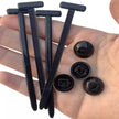Hand holding black plastic components on a white background