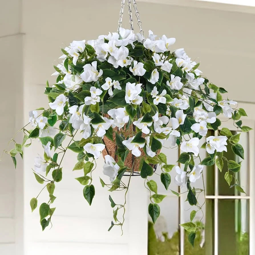Hanging basket with white flowers and green leaves against a neutral background