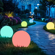 Colorful glowing balls on a garden path at night