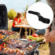 Person grilling outdoors with a close-up of a black grill brush.