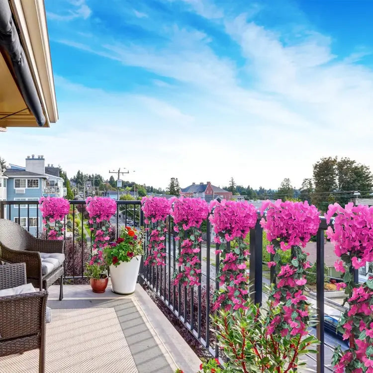 Balcony with pink flowering plants against a blue sky