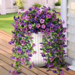 Artificial flower arch with purple and pink flowers on a wooden deck.