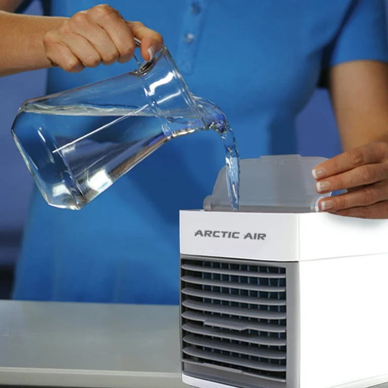 Person pouring water into a white Arctic Air humidifier.