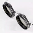 Two black camera lens filters with metal frames on a white background