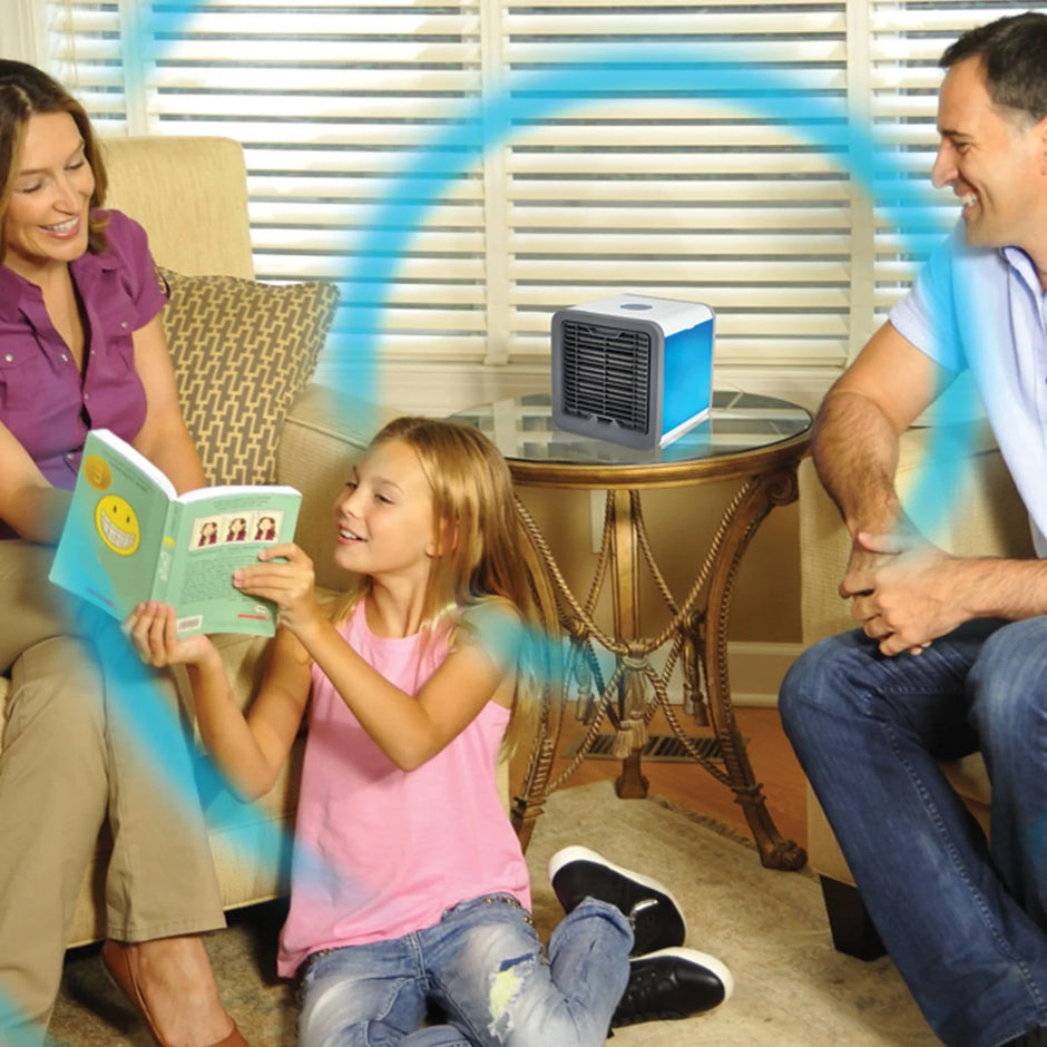 Family sitting on a couch with a small air cooler on a table in the background