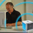 Man using a computer with a small air conditioner on the desk