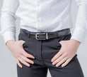 Person wearing a white shirt and dark pants with a belt on a light gray background