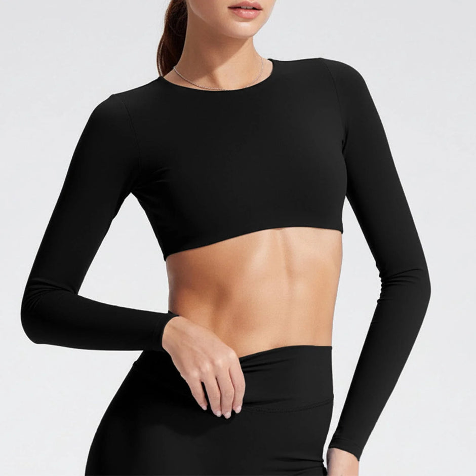 Person wearing a black long-sleeve crop top on a light gray background
