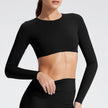 Person wearing a black long-sleeve crop top on a light gray background
