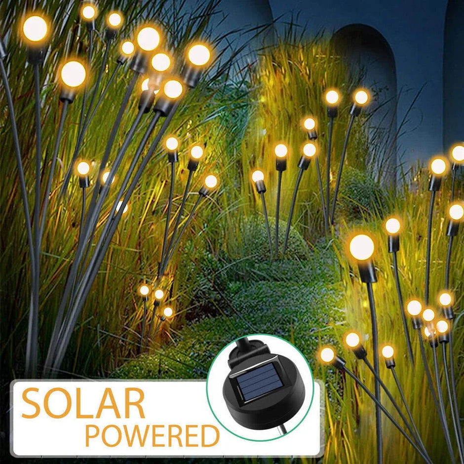 Solar-powered outdoor lights in a garden setting with grass and plants.