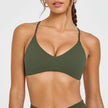 Woman wearing a green bikini top against a white background