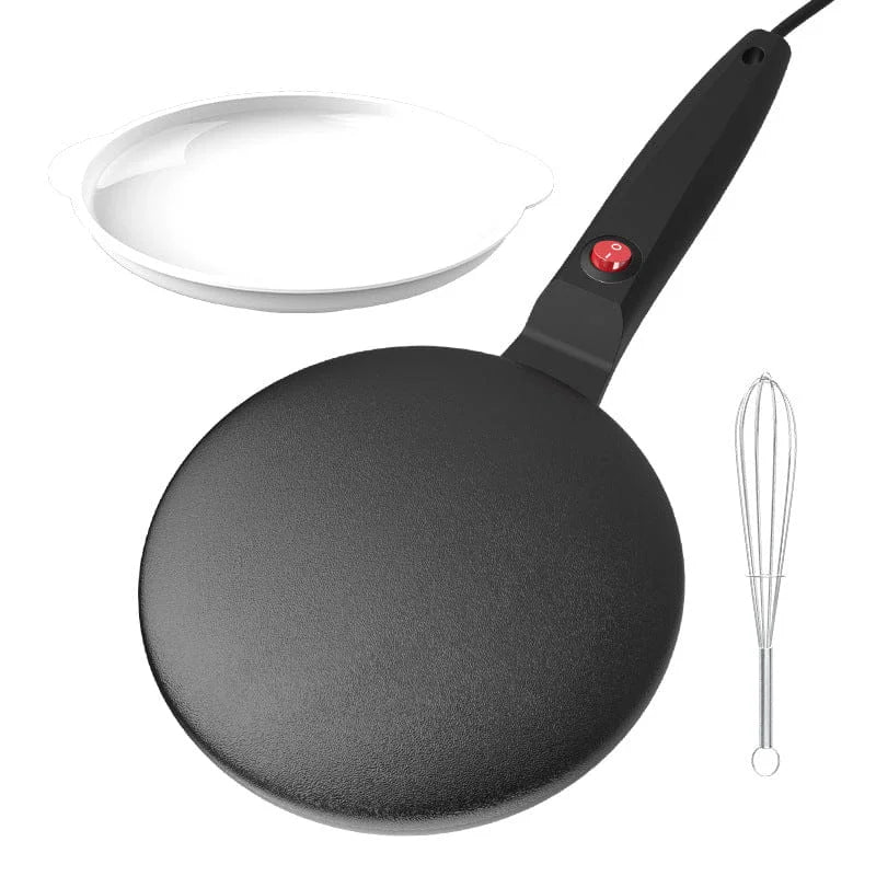 Black crepe pan with a white bowl and whisk on a white background