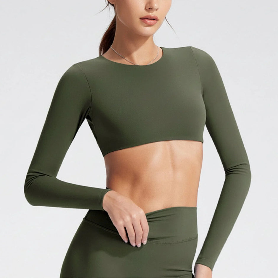 Person wearing a green long-sleeve athletic top and leggings on a light gray background