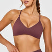 Woman wearing a maroon sports bra on a white background