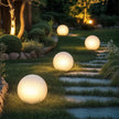 Glowing spherical outdoor lights on a garden path at night