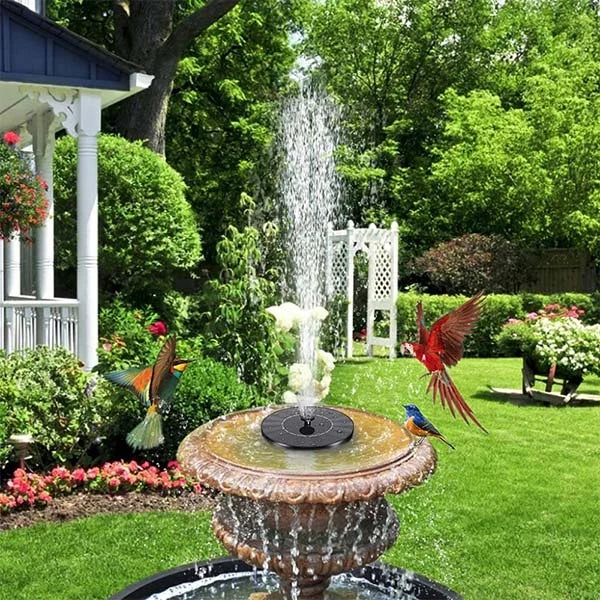 Decorative garden fountain with solar panel and bird statues in a lush green garden.
