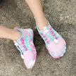 Pink and blue athletic shoes on a concrete surface