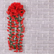 Red artificial flower garland against a gray brick wall