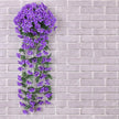 Artificial purple flower vine against a gray brick wall