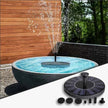 Solar water fountain in a garden setting with wooden wall and trees in the background