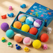 Colorful bath bombs in a gift box with toy figures on a wooden surface
