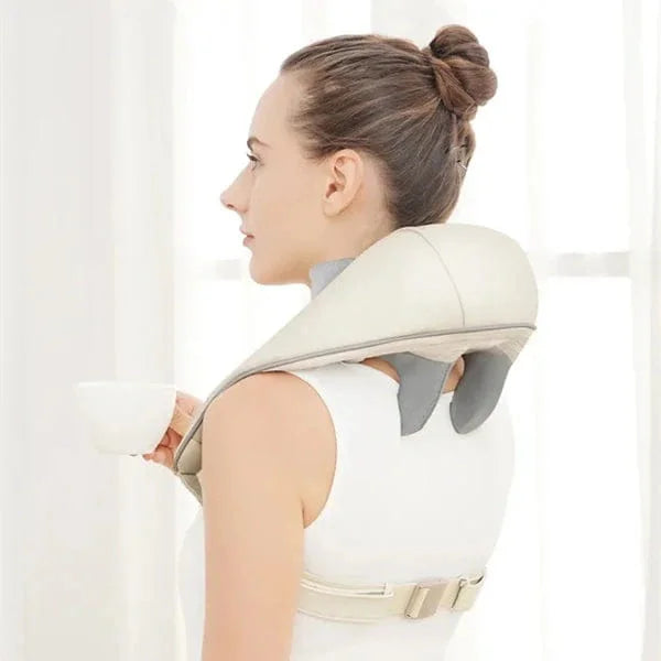 Woman using a neck and shoulder massager against a white background