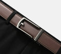 Brown leather belt with silver buckle on a black background
